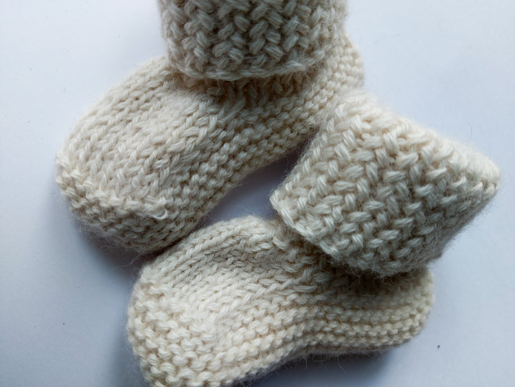 Pile of baby alpaca woolen sweaters is radiant colors. Sweaters are unorganised, but you can see their pattern and details.