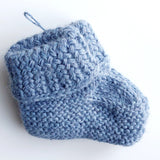 Handmade knitted baby socks in light blue with folded ankle cuffs, made from 100% baby alpaca wool—soft, stretchy, and perfect for little feet.