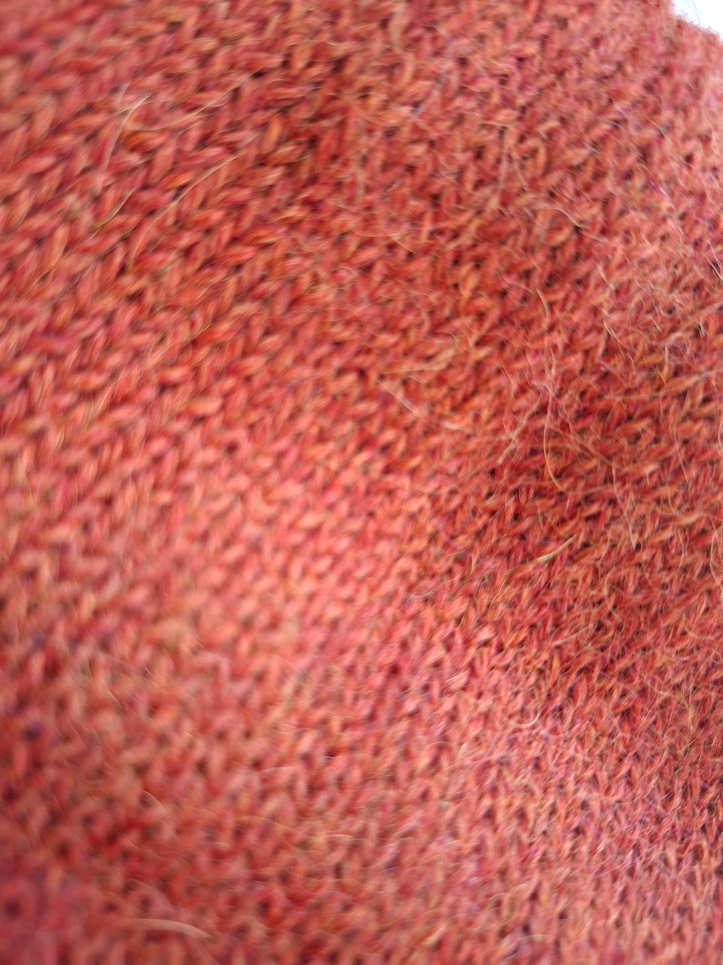 Close-up of a textured orange wool fabric surface