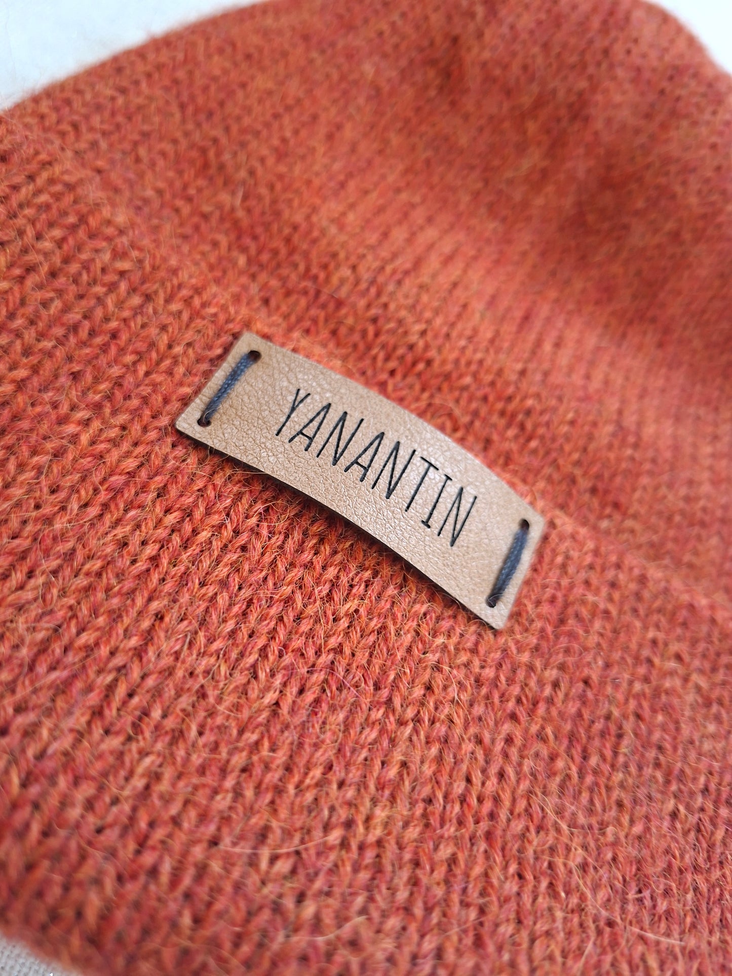 Orange alpaca wool knit hat with a 'YANANTIN' label on a white background