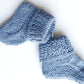 Handmade knitted baby socks in light blue with folded ankle cuffs, made from 100% baby alpaca wool—soft, stretchy, and perfect for little feet.
