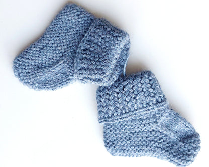 Handmade knitted baby socks in light blue with folded ankle cuffs, made from 100% baby alpaca wool—soft, stretchy, and perfect for little feet.
