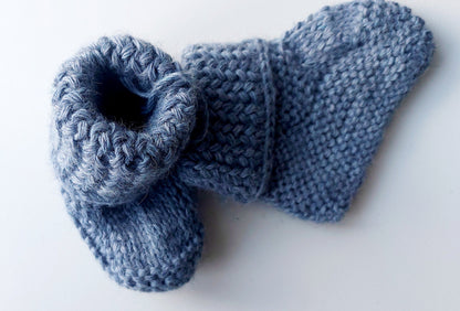 Handmade knitted baby socks in light blue with folded ankle cuffs, made from 100% baby alpaca wool—soft, stretchy, and perfect for little feet.