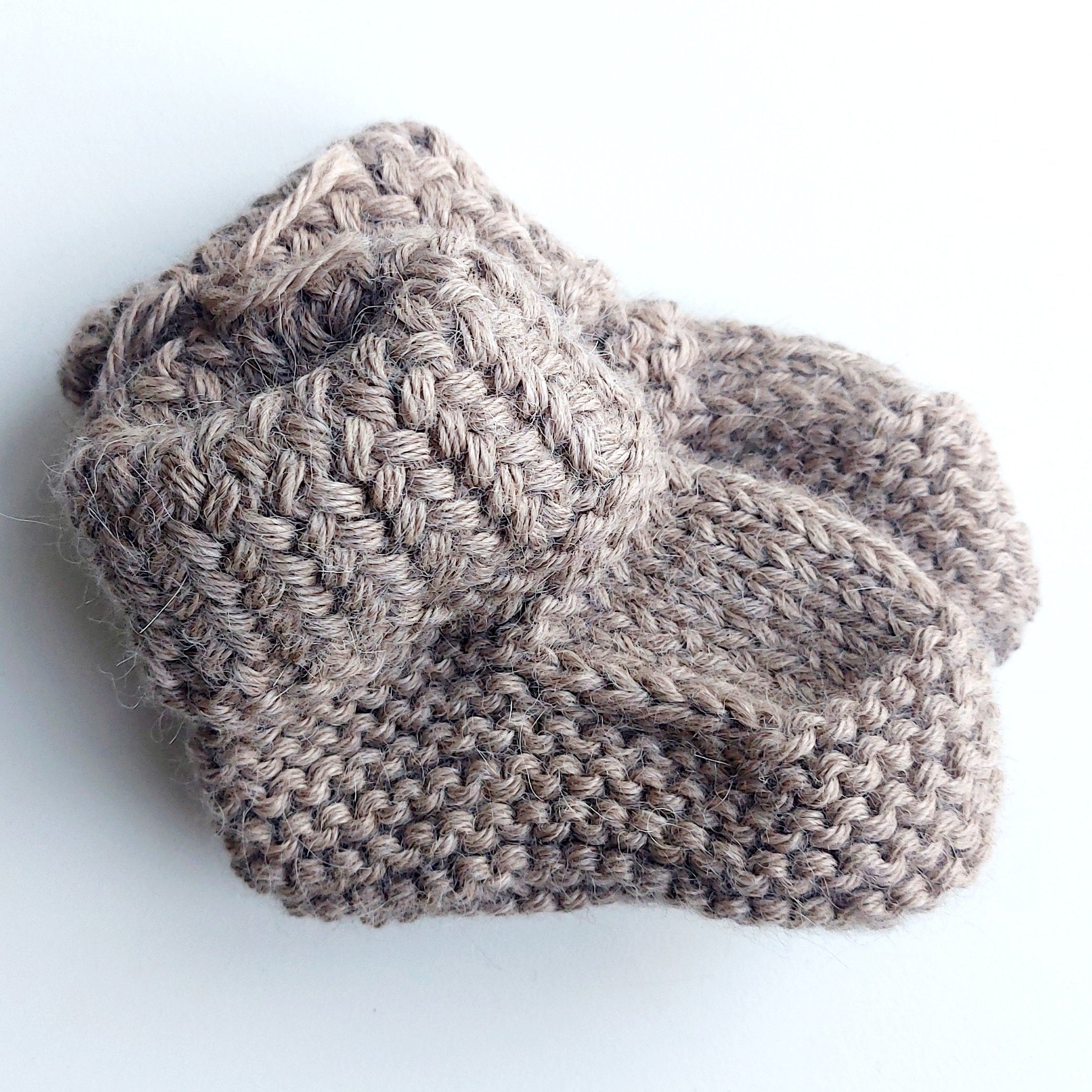 Handmade knitted baby socks in light brown with folded ankle cuffs, made from 100% baby alpaca wool—soft, stretchy, and perfect for little feet.