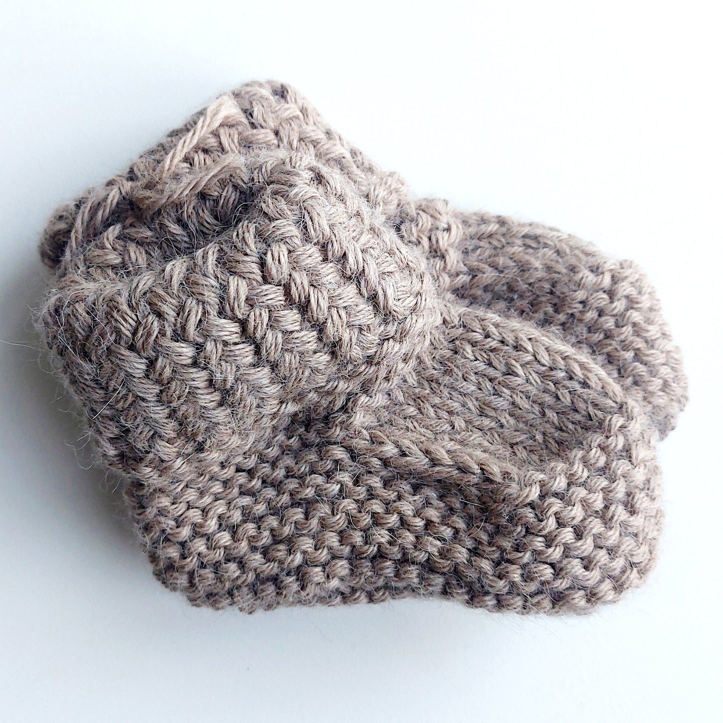 Handmade knitted baby socks in light brown with folded ankle cuffs, made from 100% baby alpaca wool—soft, stretchy, and perfect for little feet.