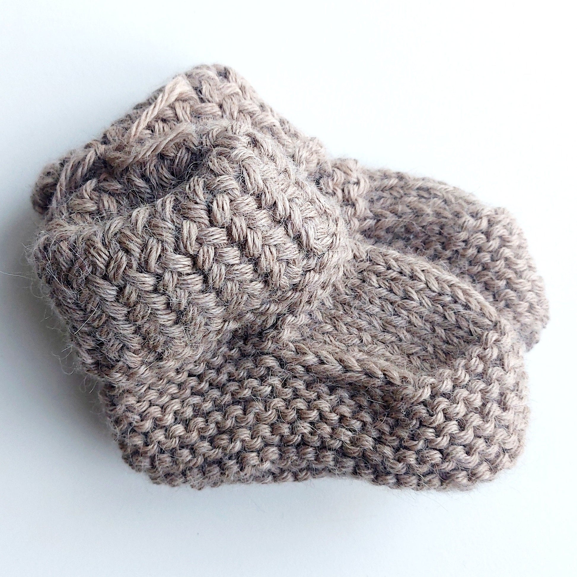 Handmade knitted baby socks in light brown with folded ankle cuffs, made from 100% baby alpaca wool—soft, stretchy, and perfect for little feet.