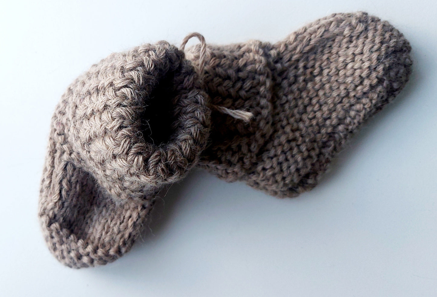 Handmade knitted baby socks in light brown with folded ankle cuffs, made from 100% baby alpaca wool—soft, stretchy, and perfect for little feet.