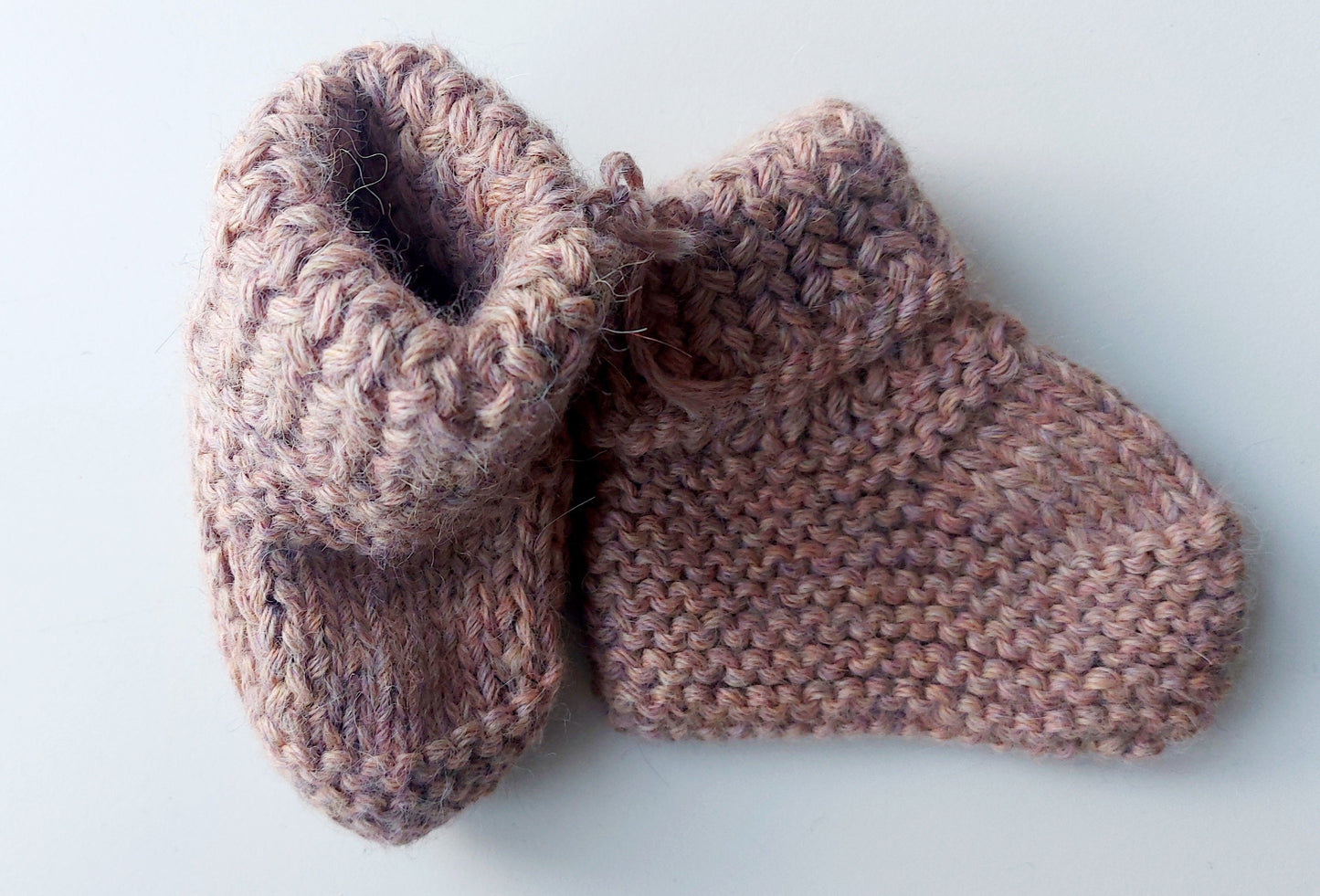 Handmade knitted baby socks in light pink with folded ankle cuffs, made from 100% baby alpaca wool—soft, stretchy, and perfect for little feet.