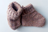 Handmade knitted baby socks in light pink with folded ankle cuffs, made from 100% baby alpaca wool—soft, stretchy, and perfect for little feet.
