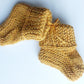 Handmade knitted baby socks in ochre yellow with folded ankle cuffs, made from 100% baby alpaca wool, soft and stretchy.
