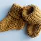 Handmade knitted baby socks in ochre yellow with folded ankle cuffs, made from 100% baby alpaca wool, soft and stretchy.