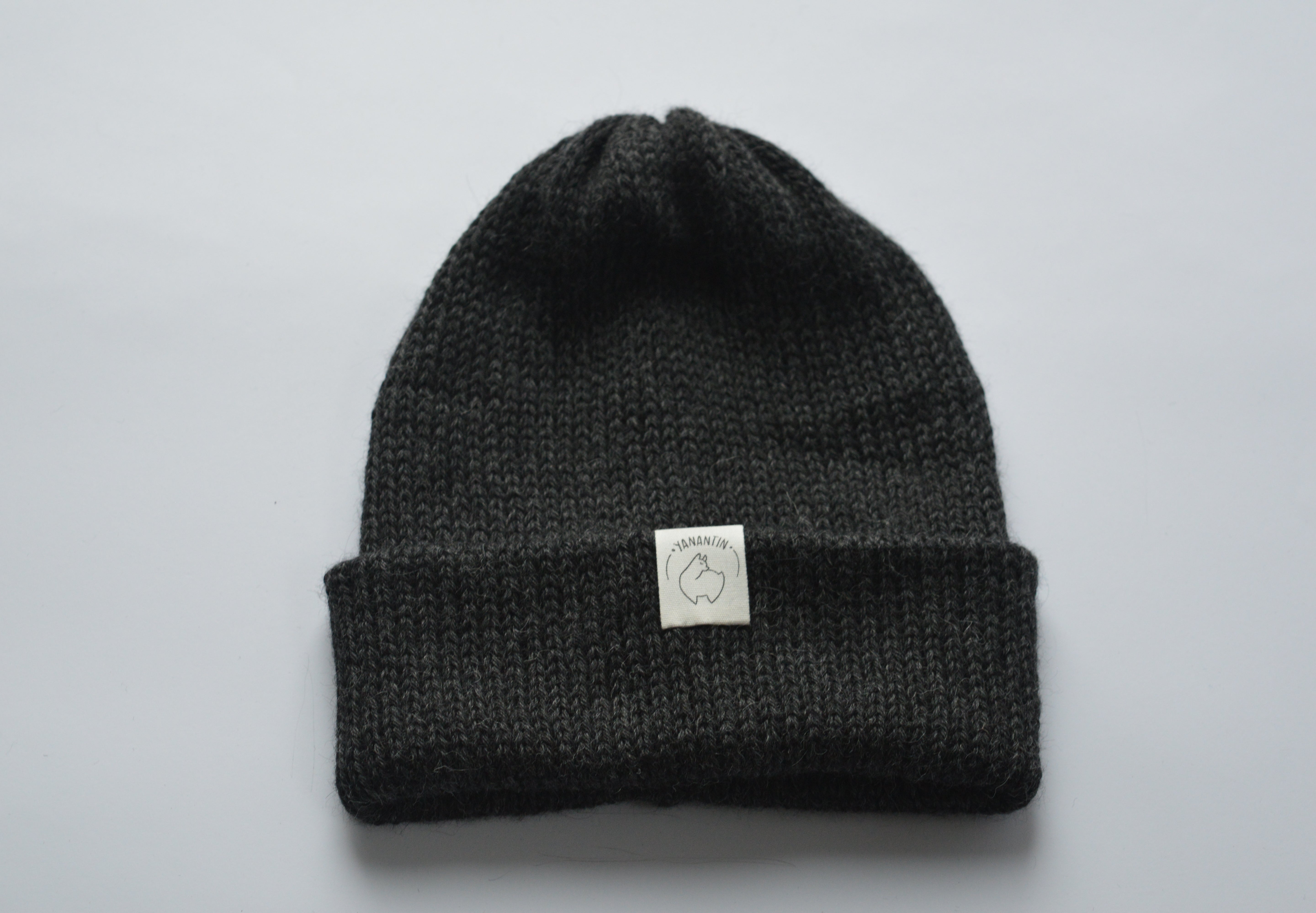Dark gray baby alpaca knit beanie with a white organic cotton label and a folded brim