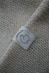 White organic cotton logo of a cute alpaca featuring the brand 'YANANTIN' on a white woolen hat