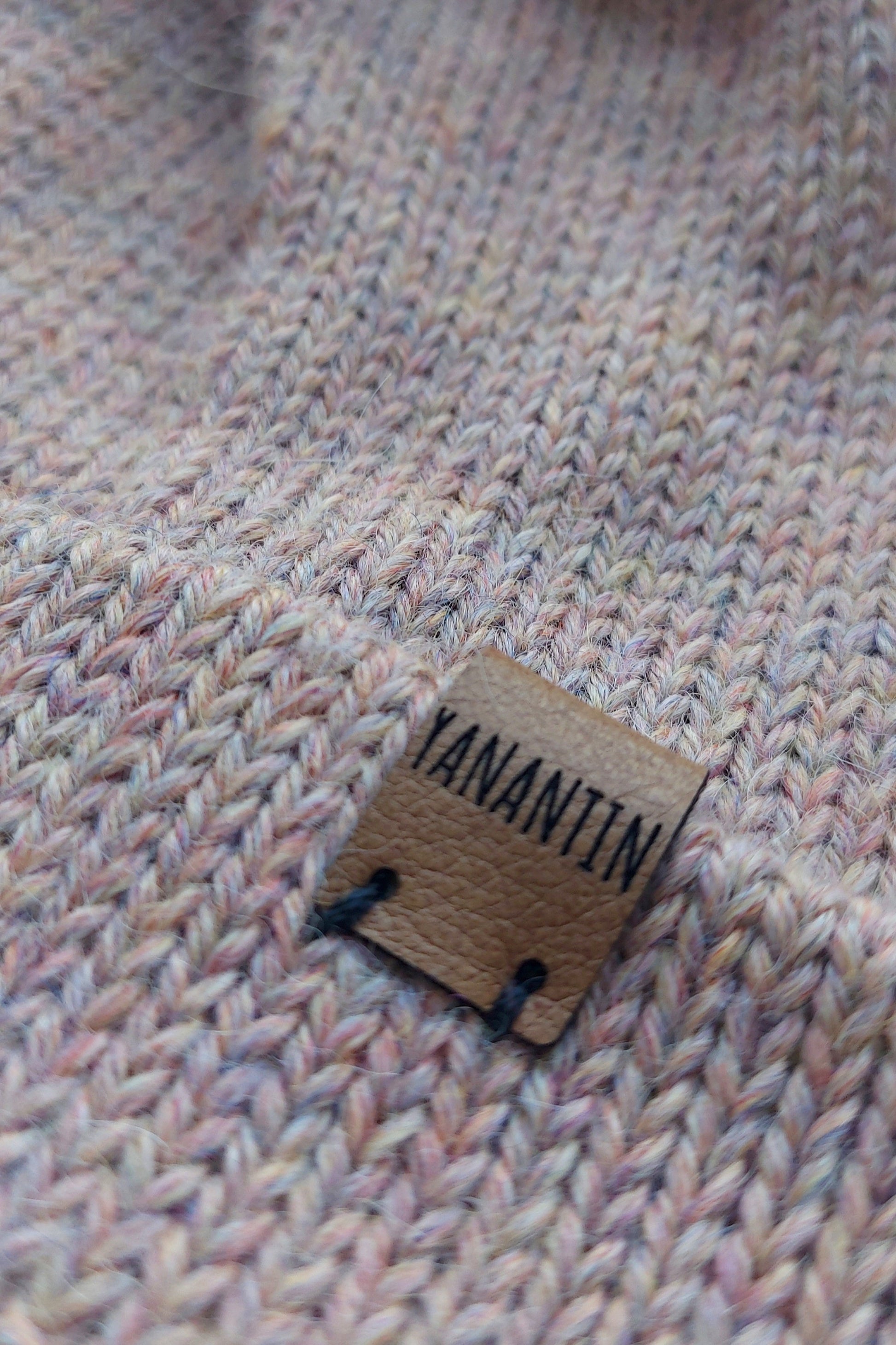 Close-up of the brown vegan leather label on the handmade light pink baby hat.