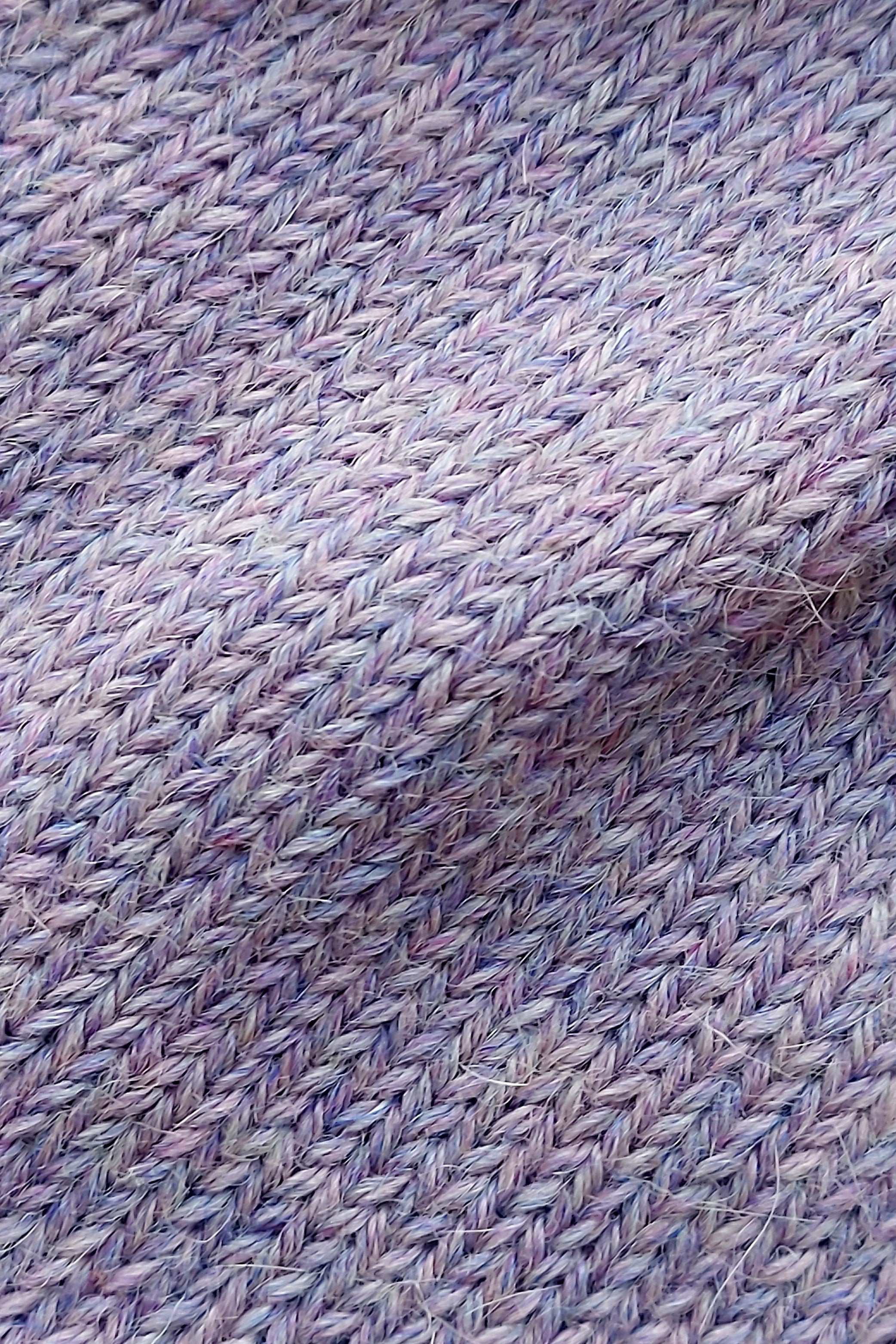Close-up of the soft knitted texture of the handmade lila baby hat, made from 100% baby alpaca wool with a foldable edge and pompom.
