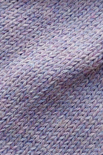 Close-up of the soft knitted texture of the handmade lila baby hat, made from 100% baby alpaca wool with a foldable edge and pompom.
