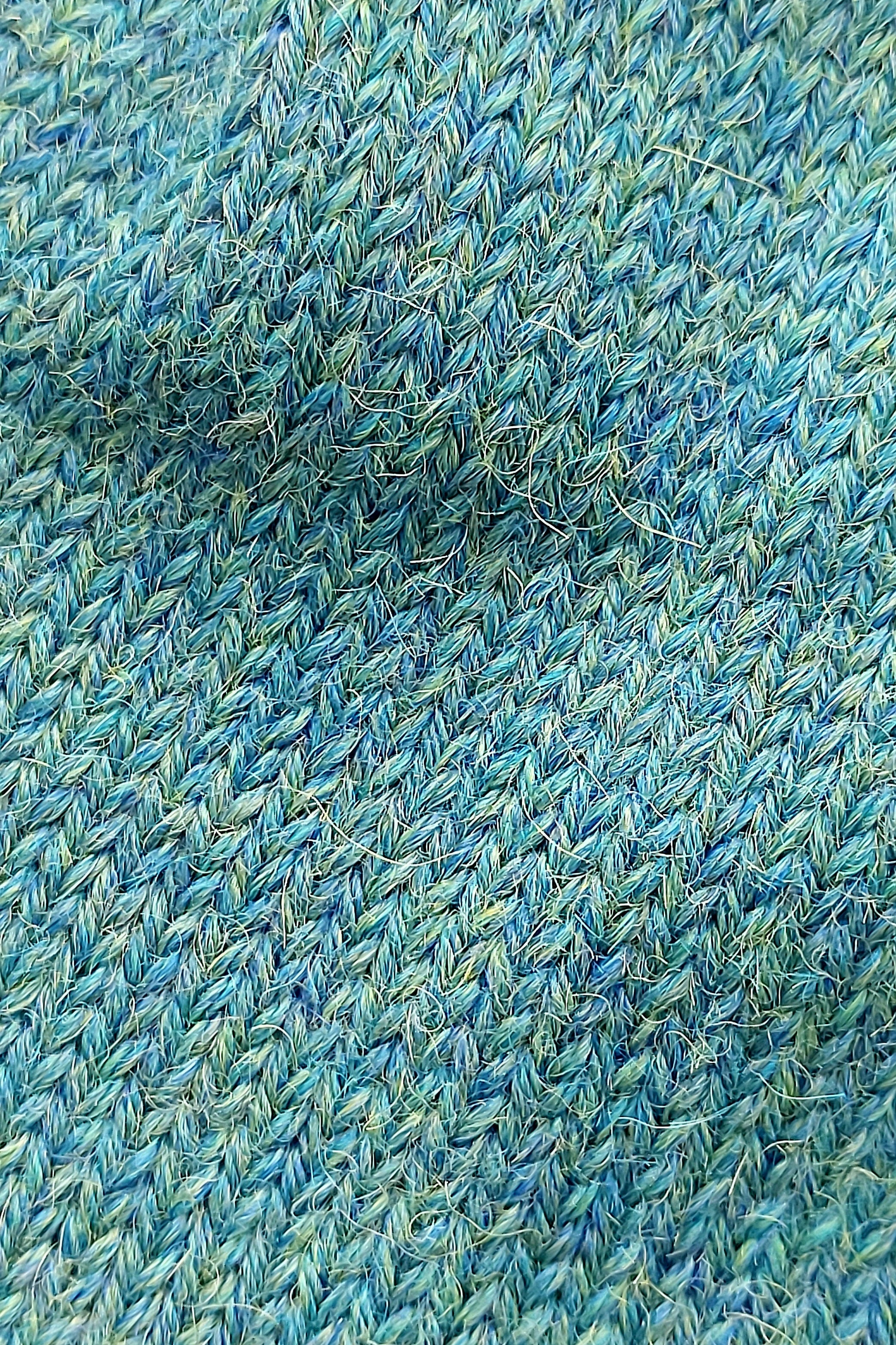 Close-up of the knitted texture on the handmade peacock blue baby hat, made from 100% baby alpaca wool.