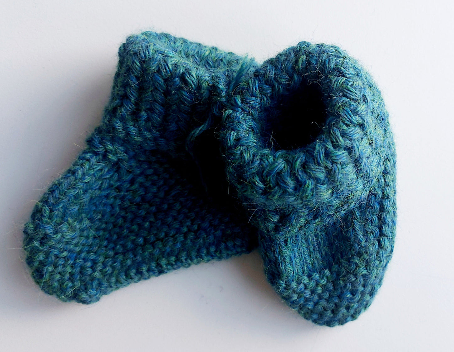 Handmade knitted baby socks in peacock blue with folded ankle cuffs, made from 100% baby alpaca wool, soft and stretchy.