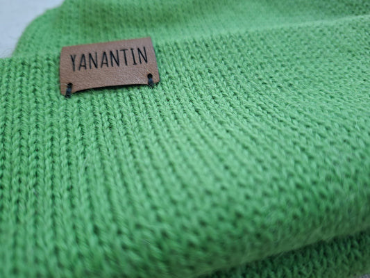Close-up of a green knitted fabric with a 'YANANTIN' label.